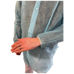 Blouse bleue non tissée 30 g à pressions et poignets élastiques : portée, détail de la manche et du poignet élastiqué